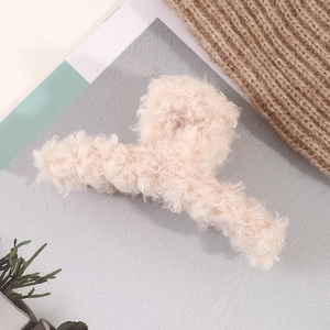 Detailed view of soft cream lamb wool plush hair claw clip on cozy knitted sweater