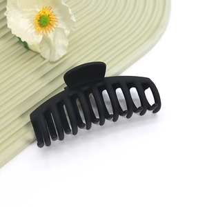 Détail macro de la grande pince à cheveux noire mate avec dents solides et finition givrée