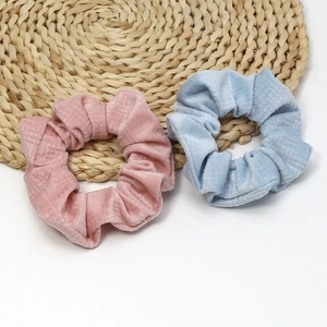 Detail of pink and light blue velvet scrunchies set with a soft grid texture on white background