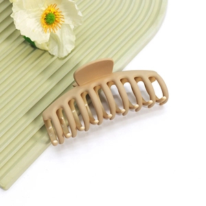Pince à cheveux marron clair mat avec design multi-dents sur surface ondulée