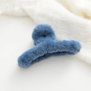 Dettaglio di un mollettone per capelli in morbido peluche azzurro con pelliccia sintetica