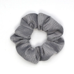Macro detail of grey velvet scrunchie showing fabric texture and pleated structure