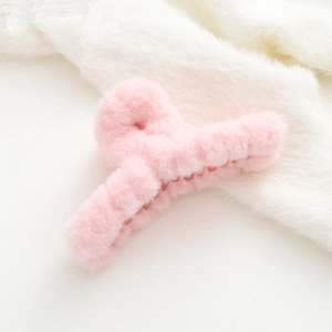 Dettaglio della pinza per capelli in peluche rosa chiaro con finta pelliccia di coniglio
