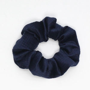 Detail view of navy blue velvet scrunchie featuring classic plaid texture and ruffled design