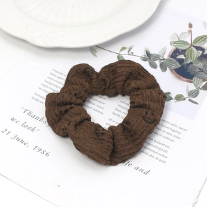 Chouchou gaufré marron avec motifs sourires sur une carte présentoir élégante