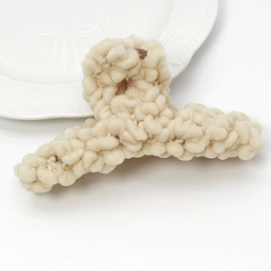 Pince à cheveux tricotée chic en laine blanc crème avec une texture en peluche douce