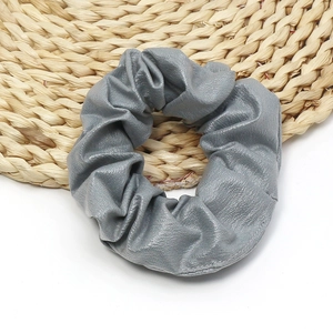 Detailed close-up showing the soft grey PU leather texture of the elastic hair scrunchie