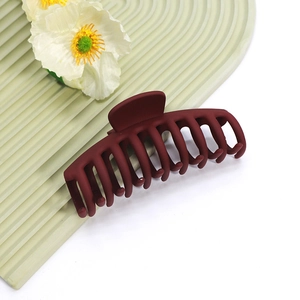 Grande pince à cheveux mate bordeaux pour cheveux longs sur fond décoratif