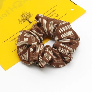 Détail d'un chouchou marron avec motifs géométriques en coton modal et élasthanne