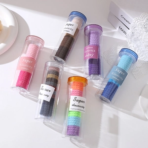 Gros plan d'élastiques à cheveux épais à texture de losange dans des tubes de rangement