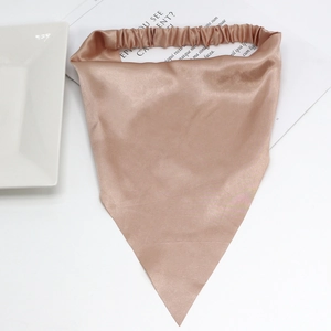 Rose gold satin triangle headscarf with elastic band shown on a white plate with a magazine