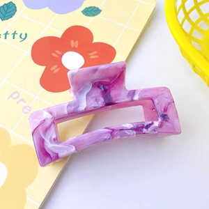 Macro detail of the purple marble acetate hair claw clip on a stylish desktop background
