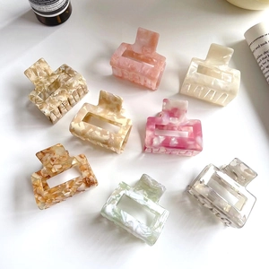 Eight marble pattern acetate hair claws in various colors with a minimalist square design