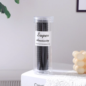 Pot d'élastiques à cheveux noirs sans couture haute élasticité sur nappe en dentelle