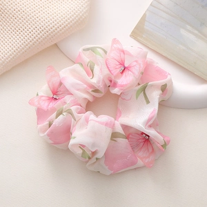 Rosa Haargummi mit 3D-Schmetterlingen und Blumenmuster auf beigem Gitterhintergrund