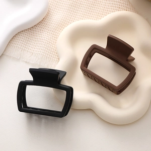 Eleganti mollette per capelli quadrate opache nere e caffè su vassoio decorativo
