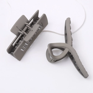 Matte grey rectangular and curved shark hair claws on a white decorative plate