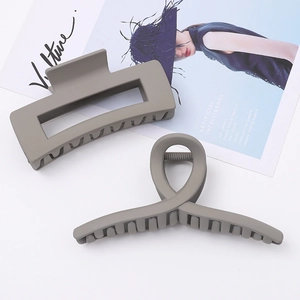 Detail view of large dark grey matte hair claws in geometric and twisted designs