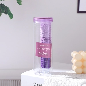 Détail d'un ensemble d'élastiques à cheveux violets dans un pot de rangement transparent