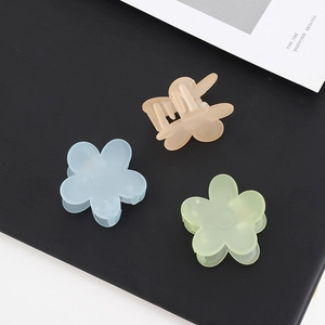Three colorful matte flower hair claw clips for ponytails in blue yellow and green