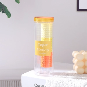 Vue détaillée d'élastiques à cheveux jaunes gaufrés dans un pot de rangement clair