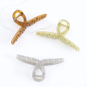 Oversized acrylic claw clips in amber, light green, and purple on white background