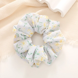 Detail of yellow floral scrunchie on waffle fabric with white wavy gypsum decor