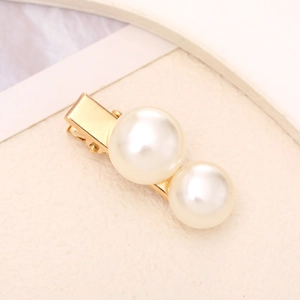 Detailed view of elegant gold-plated duckbill hair clip featuring two luminous white pearls