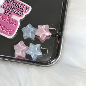 Paire de barrettes étoile scintillantes en rose et bleu pastel sur plateau