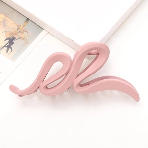 Grande pince à cheveux mate rose avec design ondulé pour femme sur fond minimaliste