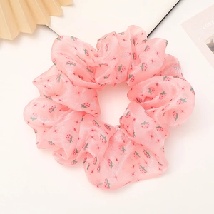 Vue détaillée du chouchou en organza rose avec motifs fraises et texture douce