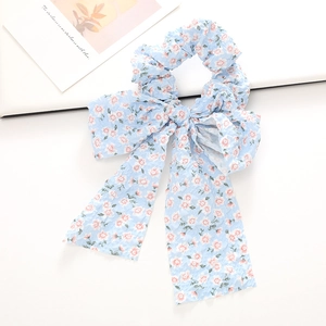 Vue détaillée du chouchou à fleurs bleu clair avec ruban long et texture en tissu seersucker