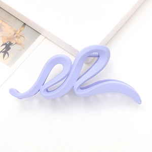Détail de la pince à cheveux violette mate avec design ondulé et dents internes