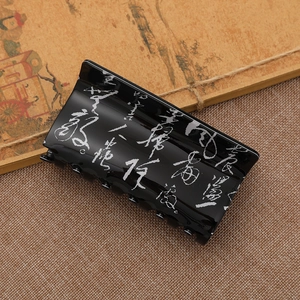 Ink calligraphy hair claw clip in black acrylic with elegant Chinese script on burlap