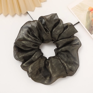 Close-up of shimmering metallic olive scrunchie with elegant pleated fabric texture