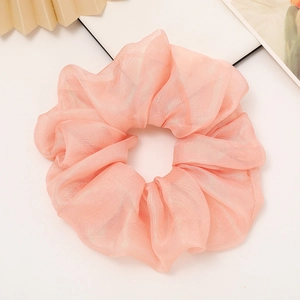 Detailed view of the peach-orange iridescent scrunchie with soft pearlescent texture