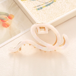 Elegant pearlescent acetate hair claw clip with golden metal base and wavy design