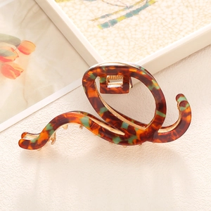 Elegant wavy acetate claw clip with vintage tortoiseshell pattern and gold metal spring