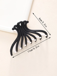 Detail shot of a matte black and white contrast hair claw clip measuring 11cm in length