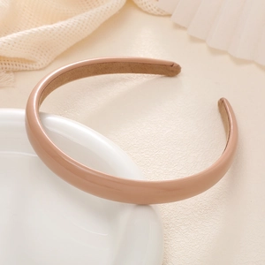 Close-up of light brown leather headband on a decorative plate with aesthetic background