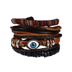 Detail of bohemian leather bracelet set featuring a blue evil eye charm and wooden beads