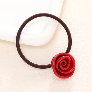 Detailed close-up of a red resin rose hair tie with a durable elastic band on a white plate