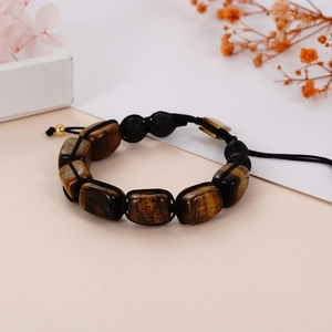 Close-up of woven yoga bracelet featuring tiger eye stone and black lava rock beads