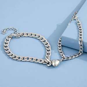 Silver thick chain couple bracelets with magnetic heart buckle on blue background