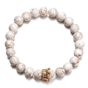 Close-up of white marble stone beads and a gold micro-pave crown on a stretch bracelet