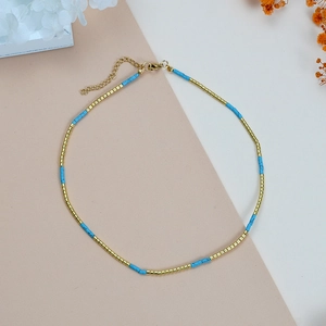 Detail van blauwe kralenketting met gouden metalen buisjes en verstelbare karabijnsluiting