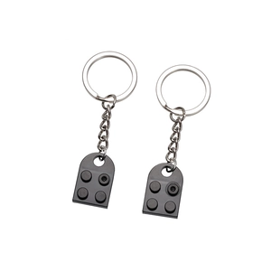 Detailed close-up of two black brick-style keychains with polished silver metal rings