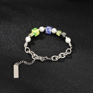 Detail van een roestvrijstalen kralenarmband met parels en vierkante natuurstenen bedels