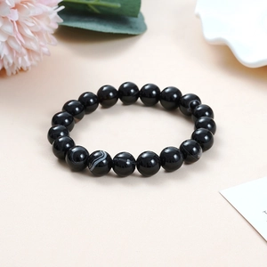 Detail of natural black obsidian beaded bracelet showing glossy finish and silk texture