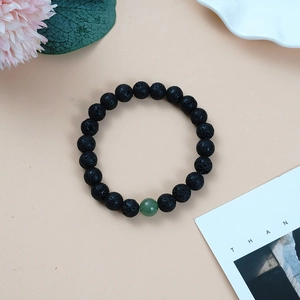 Minimalist beaded bracelet with natural black lava stones and one green aventurine bead